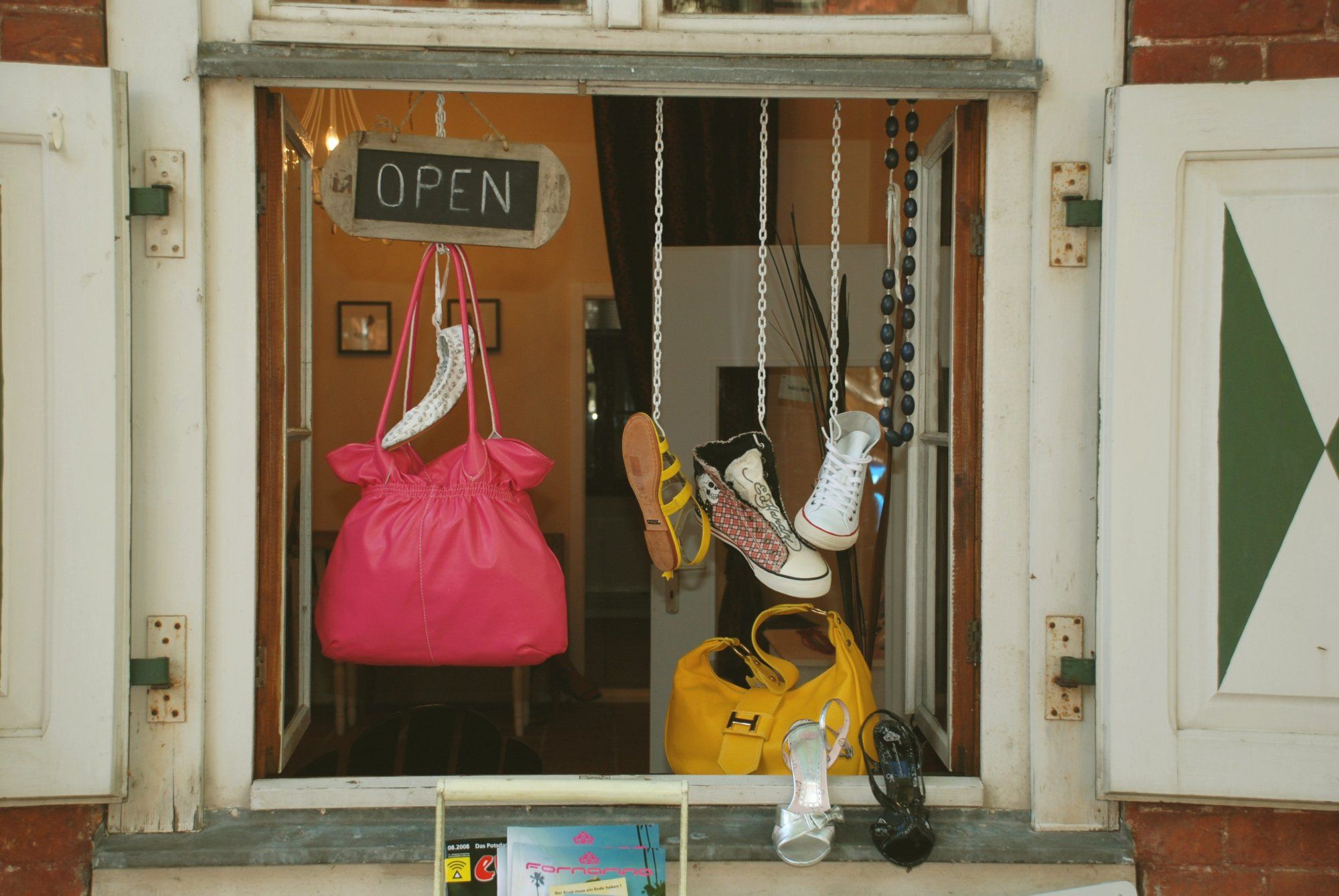 Handtaschen und Schuhe baumeln in einem Schaufenster